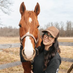 woman holding horse during horse therapy outside